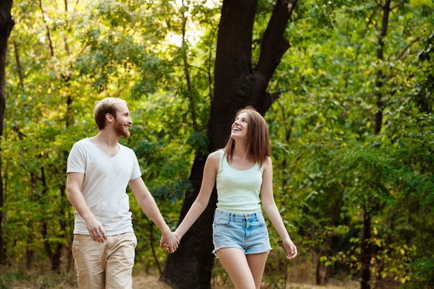 Young beautiful couple resting, walking in park, smiling, rejoicing.