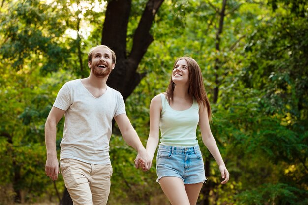 Young beautiful couple resting, walking in park, smiling, rejoicing.