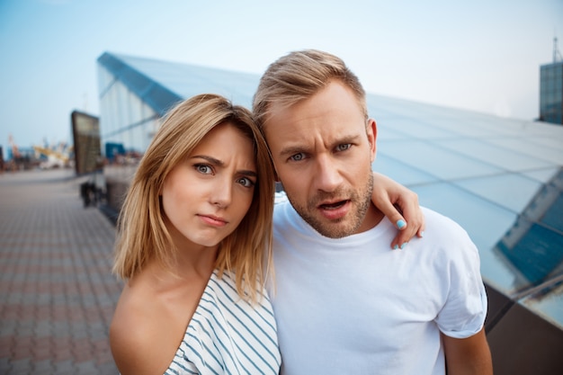 Young beautiful couple smiling, embracing, walking around city.