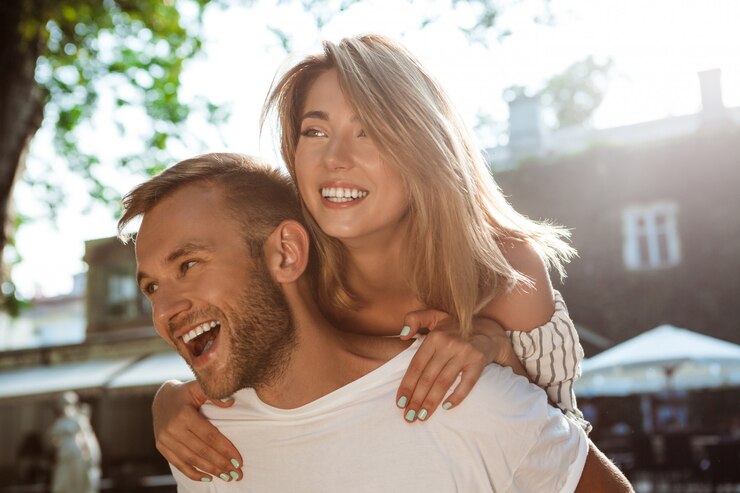 Free Photo young beautiful couple smiling, embracing, walking in park.