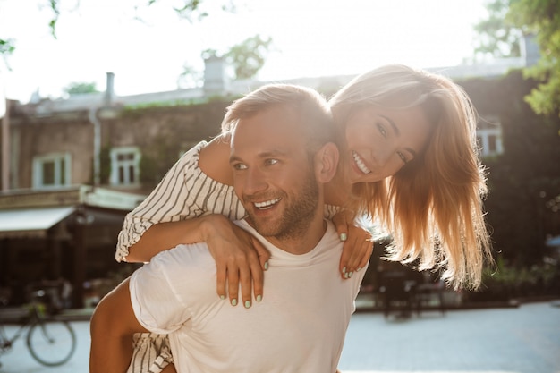 Young beautiful couple smiling, embracing, walking in park.