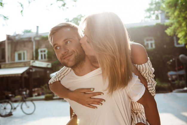 笑顔、キス、抱きしめる、公園を歩いている若い美しいカップル。