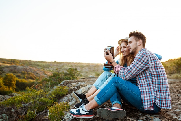 Young beautiful couple smiling, taking picture of canyon landscape
