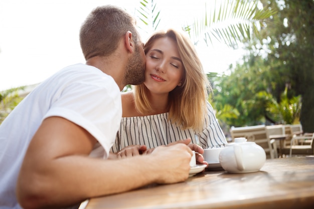 Free photo young beautiful couple speaking, smiling, resting in cafe.