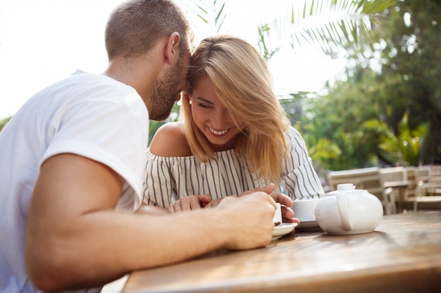 Молодая красивая пара, выступая, улыбаясь, отдыхая в кафе.