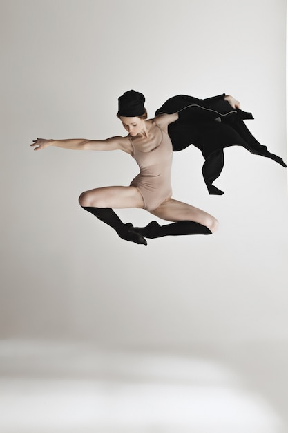 Foto gratuita giovane bello ballerino nel dancing beige del costume da bagno sul gray