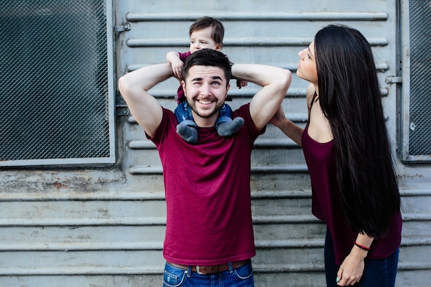 Young beautiful family with child posing on the building