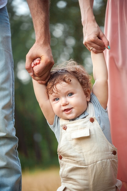 Young beautiful father, mother and little toddler son outdoors