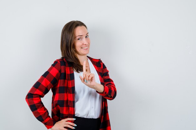 Young beautiful female in casual outfit showing hold on a minute gesture and looking blissful , front view.