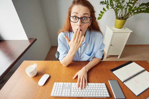 Free photo young beautiful female office worker looking in surprise