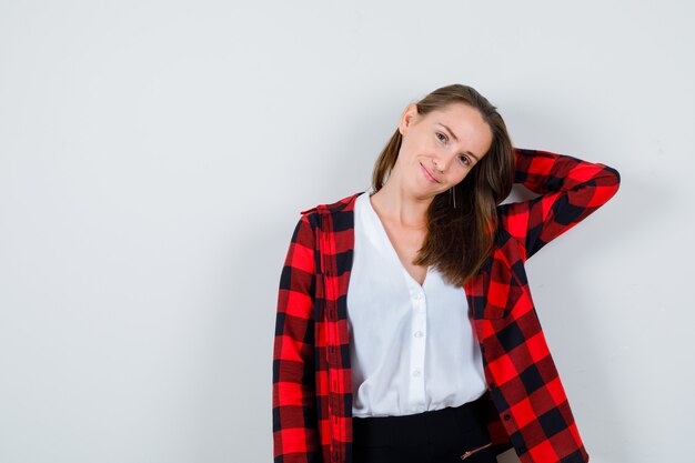 Young beautiful female posing while with hand behind head in casual outfit and looking charming , front view.