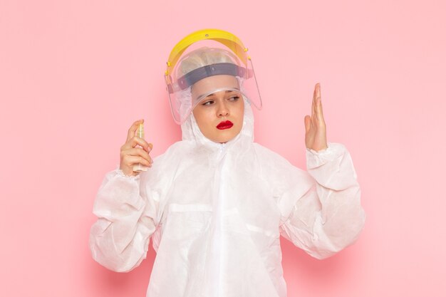 young beautiful female in special white suit holding spray on pink