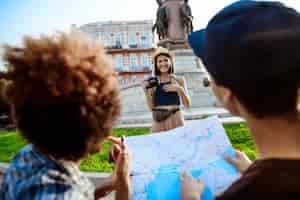 Foto gratuita giovane bella turista femminile sorridente, scattare foto dei suoi amici.