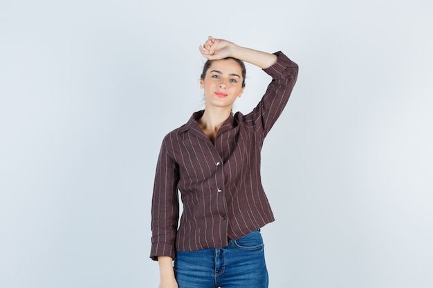 Free photo young beautiful female with hand on head in jacket and looking optimistic. front view.