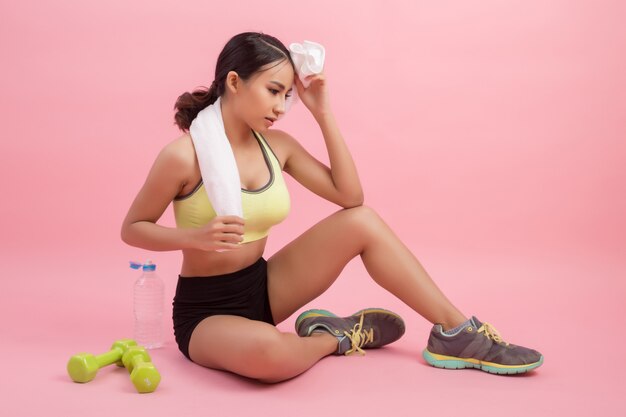 Young beautiful fit woman drinking water after exercise