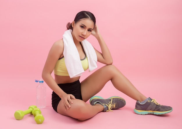 Young beautiful fit woman drinking water after exercise