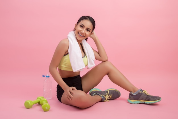 Young beautiful fit woman drinking water after exercise