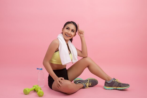 Young beautiful fit woman drinking water after exercise