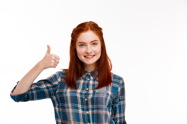  young beautiful ginger girl over white wall.