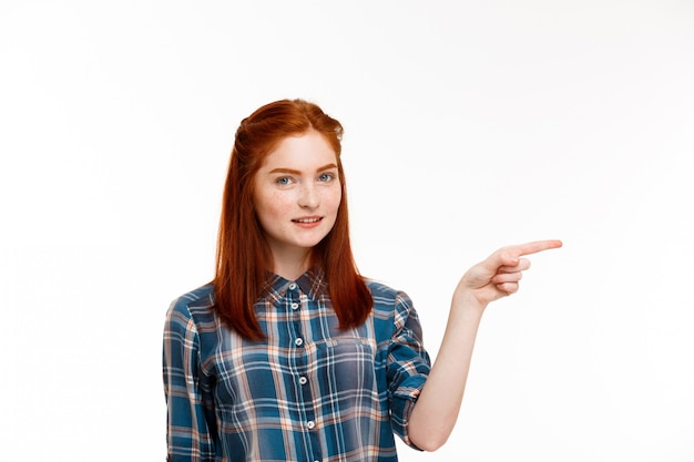  young beautiful ginger girl over white wall.