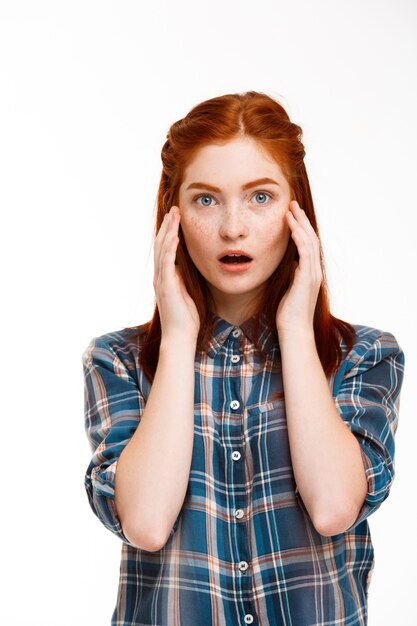  young beautiful ginger girl over white wall.