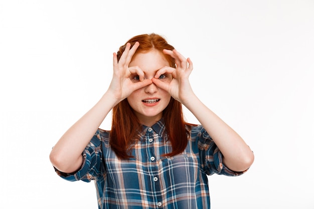 young beautiful ginger girl over white wall.