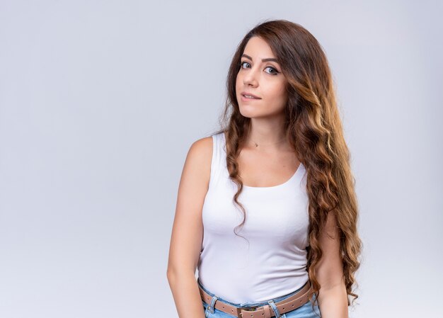 Young beautiful girl biting her lip on isolated white wall with copy space