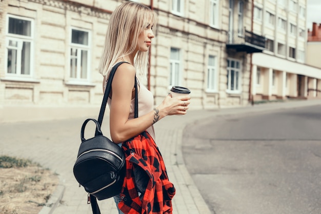 아름 다운 소녀가 거리에서 유리에 커피를 마신다, 웃음과 웃음