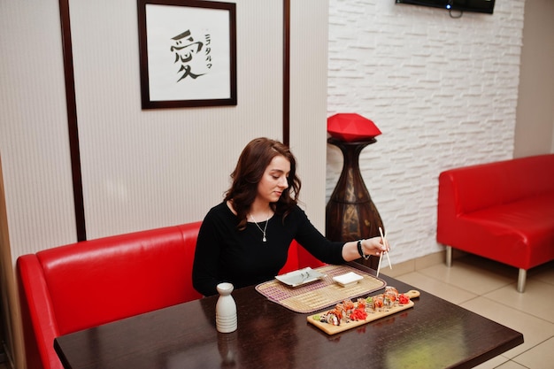 일본 전통 레스토랑에서 초밥을 먹는 아름다운 소녀