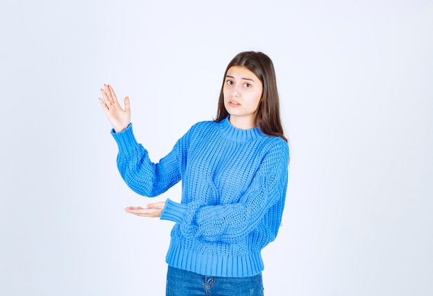 Young beautiful girl gesturing with hands showing big and large size sign.