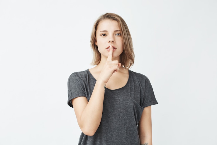 Free Photo young beautiful girl in grey t-shirt showing keep silence .