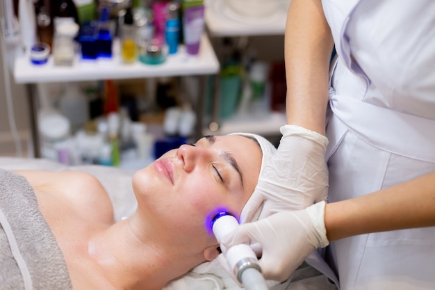 A young beautiful girl lies on the beautician's table and receives procedures