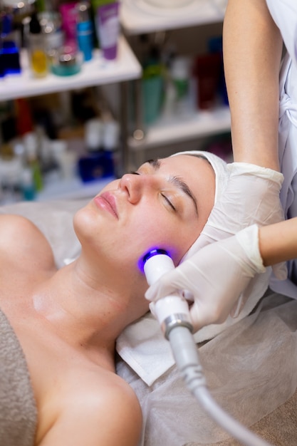 A young beautiful girl lies on the beautician's table and receives procedures