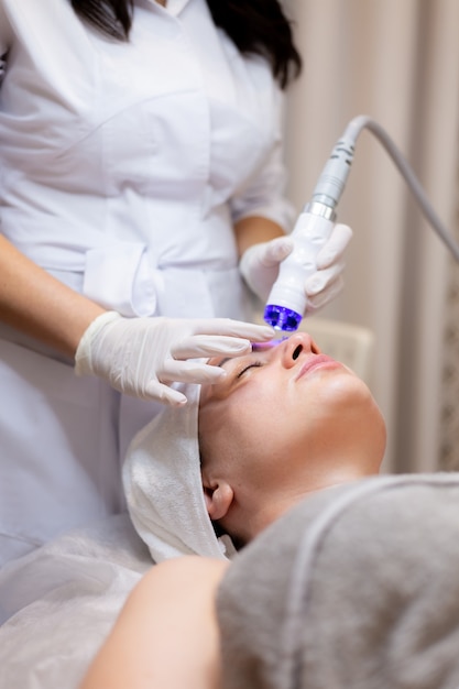 A young beautiful girl lies on the beautician's table and receives procedures