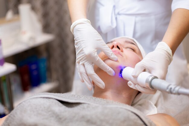 a young beautiful girl lies on the beautician's table and receives procedures