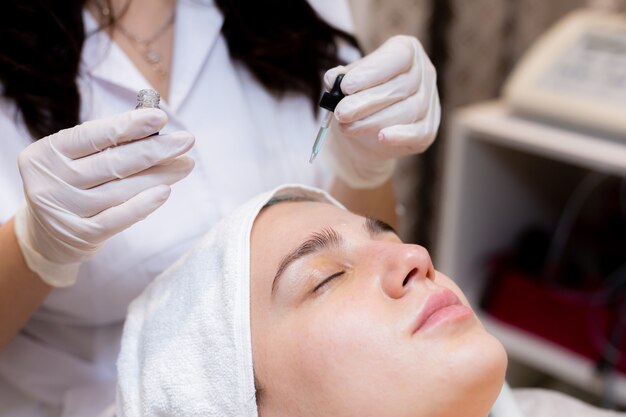 A young beautiful girl lies on the beautician's table and receives procedures