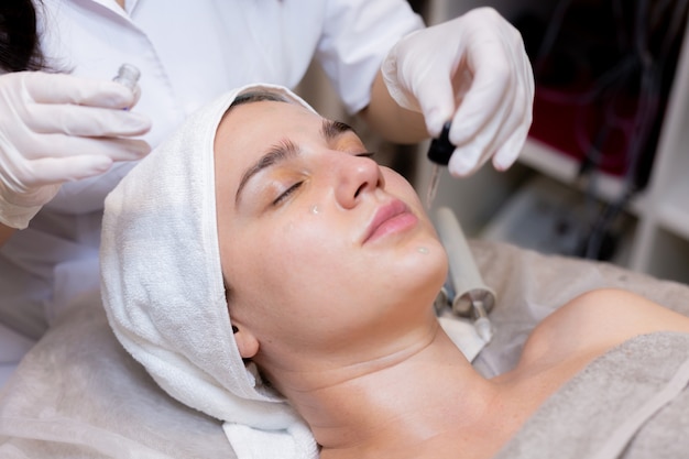 A young beautiful girl lies on the beautician's table and receives procedures