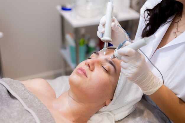 A young beautiful girl lies on the beautician's table and receives procedures