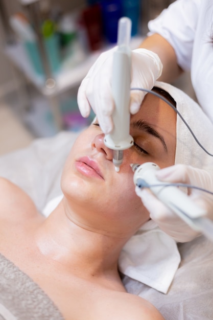 A young beautiful girl lies on the beautician's table and receives procedures