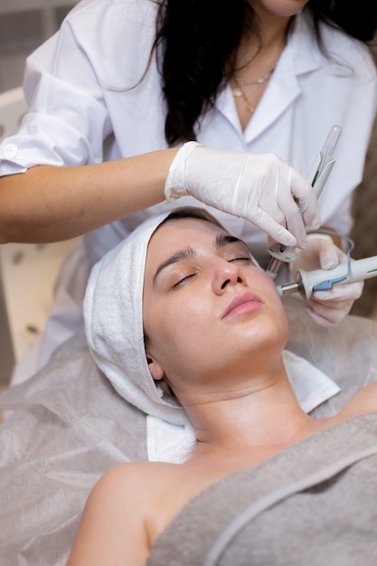 A young beautiful girl lies on the beautician's table and receives procedures