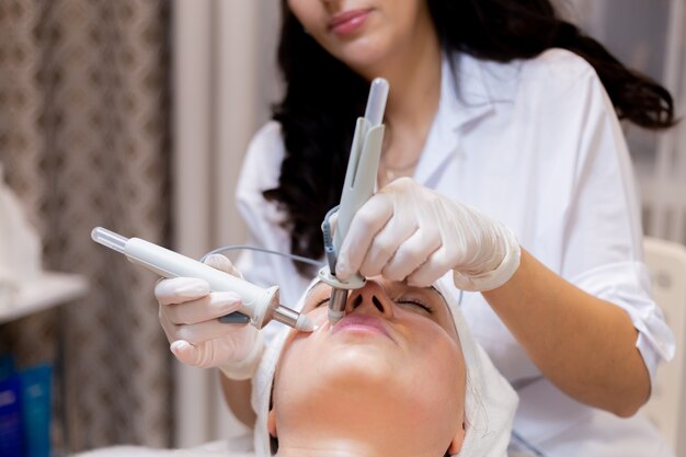 A young beautiful girl lies on the beautician's table and receives procedures