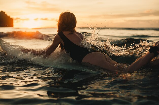 서핑 보드, 여자 서퍼, 파도와 해변에서 포즈 젊은 아름 다운 소녀
