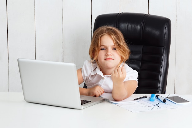 Young beautiful girl showing fist to camera at working place.