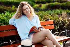 Free photo young beautiful girl sitting on bench in city park.