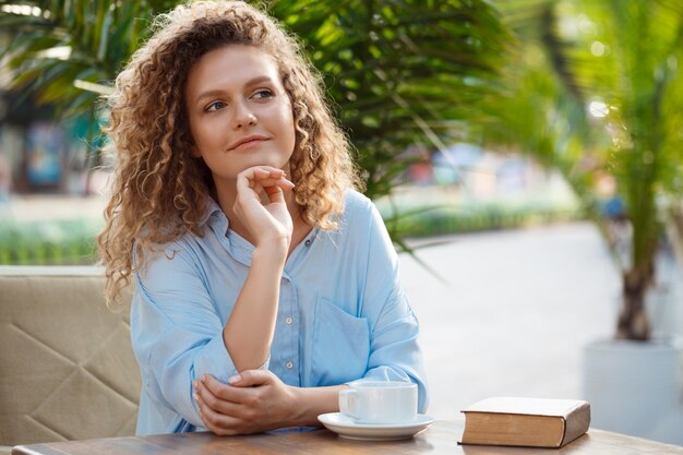 Young beautiful girl sitting in cafe.