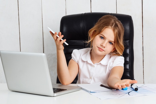 Young beautiful girl sitting at working place in office.