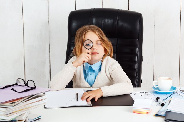 Young beautiful girl sitting at working place in office.