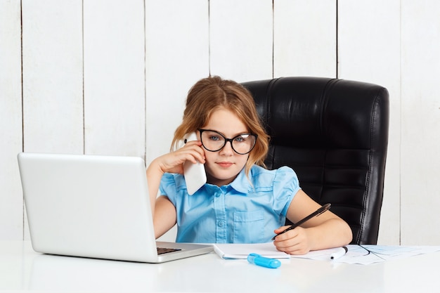 Free photo young beautiful girl speaking phone at working place in office.