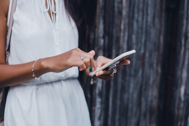 young beautiful girl uses a smartphone on the street, surfing the internet