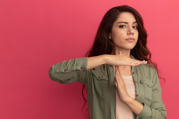 Young beautiful girl wearing olive green t-shirt - isolated on pink wall